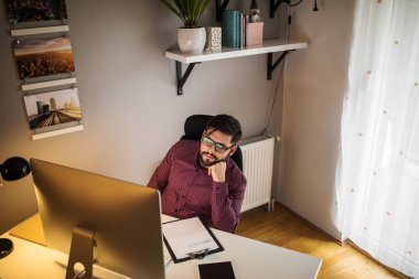 Çalışan yorgun bir genç erkeğin kadeh.