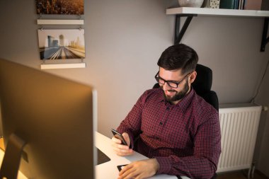 Genç hipster cep telefonunuzun ve ev ofis.