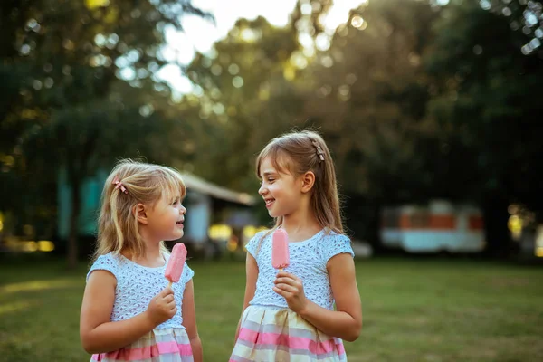 公園でアイスクリームを食べる つの美しい若い女性の肖像画 — ストック写真