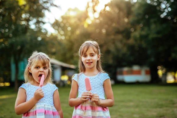 公園でアイスクリームを食べる つの美しい若い女性の肖像画 — ストック写真