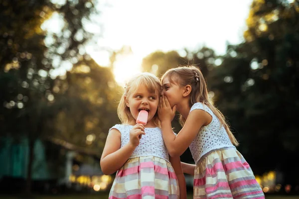 Shot Two Young Girls Whispering While Eating Ice Cream Outdoors — Stock Photo, Image