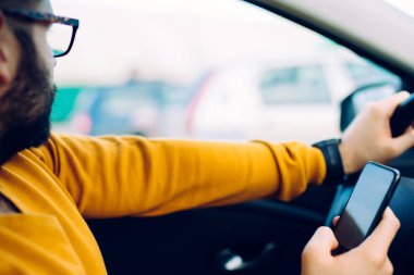 Sürüş sırasında cep telefonuyla yakışıklı bir adam fotoğrafı.