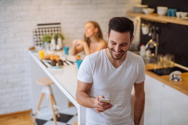 Yakışıklı adam sabah cep telefonunu kontrol.