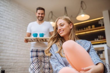Yakışıklı adam kız arkadaşına sabah kahve getiriyor.