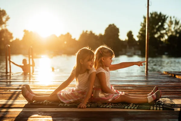 日の出で夏の日の湖の近くの公園で楽しむ金髪姉妹 — ストック写真