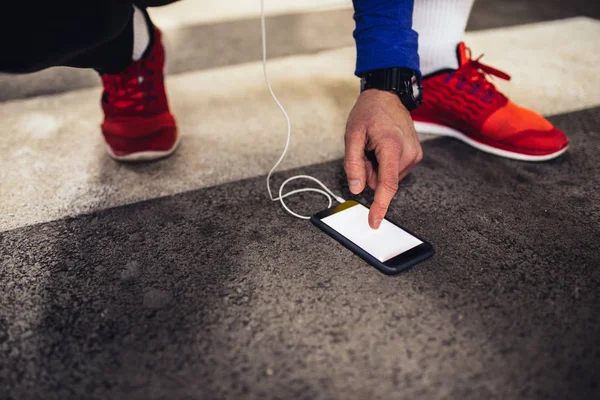 Shot of an athletic male using mobile phone during workout.