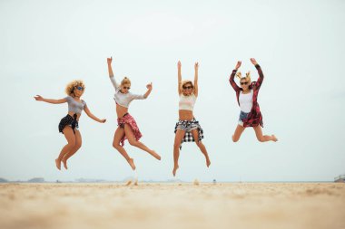 Dört en iyi arkadaşlar eğlenmeye güneşli bir günde sahilde.