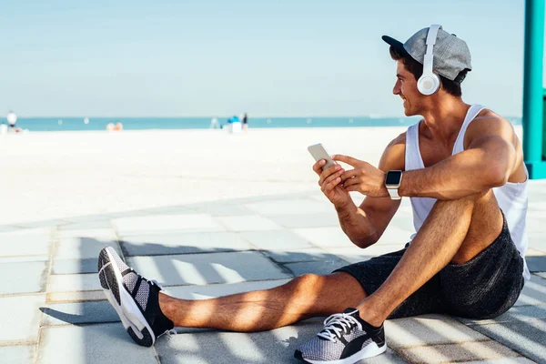 Foto Joven Sonriente Sentado Afuera Escuchando Música Mientras Disfruta Vista —  Fotos de Stock