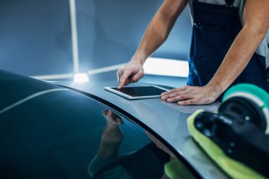 Genç erkek araba tamircisi dijital tablet kullanma.