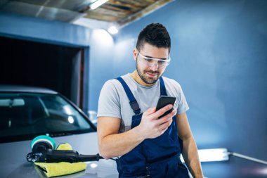 Adam manifatura bir atölyede çalışırken telefon.