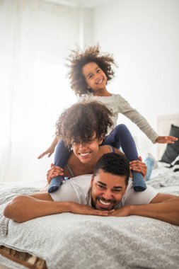Afro-Amerikan aile yatakta oynarken.