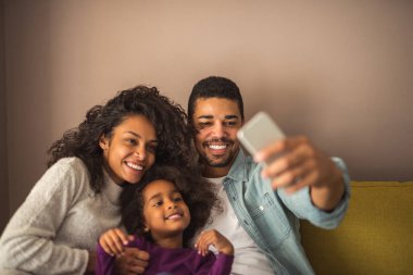 Afro-Amerikan aile evde cep telefonu ile fotoğraf çekmek.