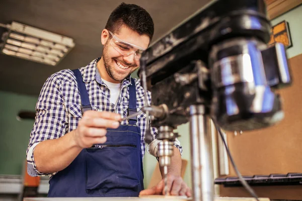 Foto Giovane Falegname Sorridente Che Lavora Con Una Perforatrice Officina — Foto Stock