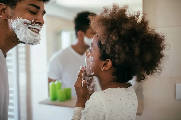 非裔美国人父亲和女儿玩剃须泡沫在浴室里的照片 — 图库照片