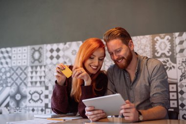 Evde online alışveriş yaparken çekici mutlu çift.