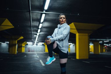 Yer altı otoparkı olarak çalışma için Isınma kadar çekici kadın atlet.