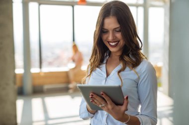 Çekici kız ofiste bir tablet üzerinde çalışan.