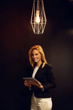 Dijital tablet kullanma gülümseyen genç iş kadını portresi.