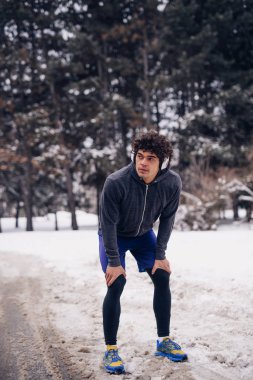 Yakışıklı adam kış fitness oturum yaparken bir mola.