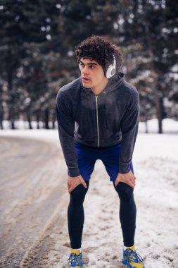 Yakışıklı adam kış fitness oturum yaparken bir mola.