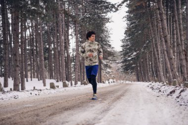 Bir kış gününde koşan yakışıklı adam.
