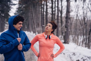 Having fun kış boyunca ormanda bir atletik çift portresi.