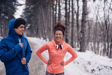 Having fun kış boyunca ormanda bir atletik çift portresi.