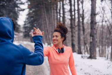 Having fun kış boyunca ormanda bir atletik çift portresi.