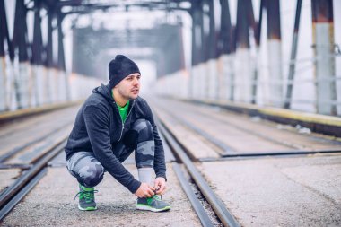 Yakışıklı adam bir bağcık bağlama ve çalıştırmak için hazırlanıyor.