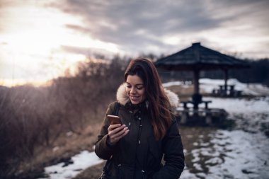 Bir dağ yürüyüş zevk ve cep telefonu tutan güzel kız.