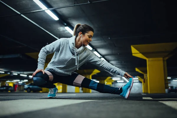 Atractiva Atleta Femenina Calentándose Para Hacer Ejercicio Aparcamiento Subterráneo — Foto de Stock