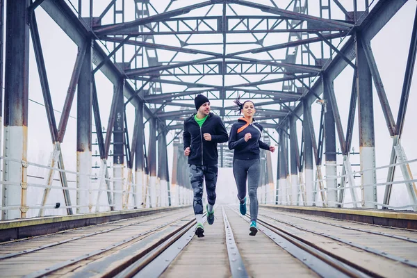 在早晨火车桥上跑步运动员朋友的照片 — 图库照片