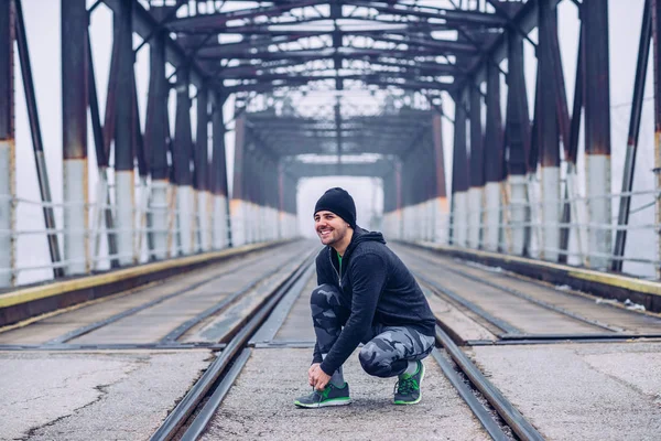 Porträtt Atletisk Man Knyta Sina Skor Bron — Stockfoto