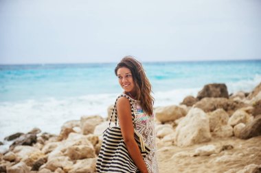 Bir çanta taşırken Sahilde yürüyüş bikinili güzel kadın.