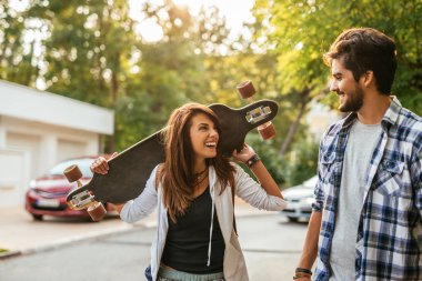 Birlikte uzun bir tahta taşıyan süre vakit zevk gülümseyen genç bir çift portresi.