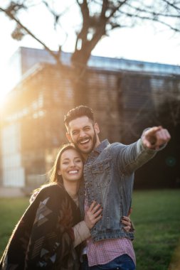 Bir kaç sarılma birbirimizi adam uzaktan günbatımında işaret ediyor iken portresi. 