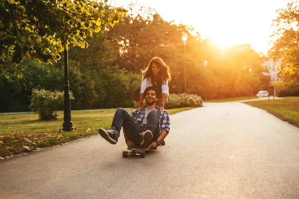 对幸福的夫妻 玩到日落的时候在户外玩滑板的镜头 — 图库照片