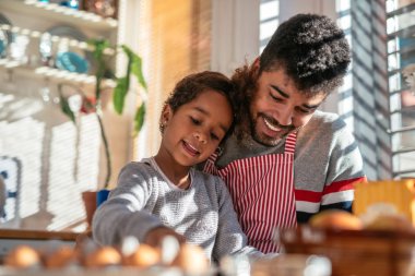 Baba ve kızı mutfakta birlikte yemek pişiriyorlar..