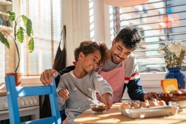 Baba ve kızı mutfakta birlikte yemek pişiriyorlar..