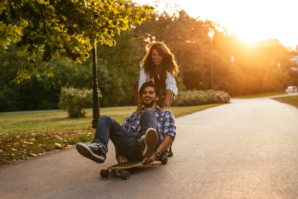 拍摄的一对年轻夫妇玩滑板在日落时分 — 图库照片