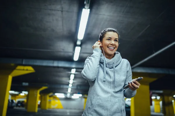 Aufnahme Einer Lächelnden Athletin Die Während Des Trainings Kopfhörer Aufsetzt — Stockfoto