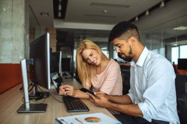 İki arkadaşları cep telefonunda bir şey izliyor.