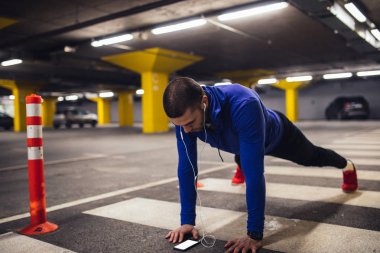 Yakışıklı sporcu yer altı otoparkı, dayanıklılık egzersizleri yapıyor.