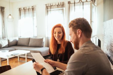 Genç çift evde kendi bütçe çalışma gülümseyen in atış.