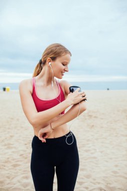 Güzel genç kadın çalışan onun çalma listesini ayarlama.