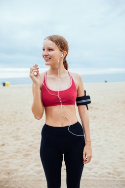 Güzel genç kadın çalışan onun çalma listesini ayarlama.