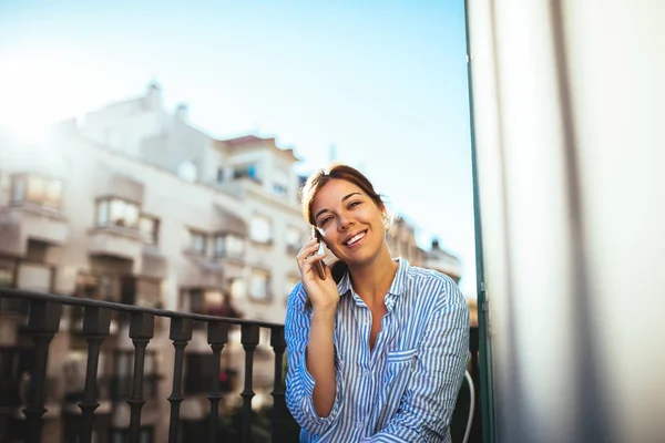Schöne Frau Telefoniert Während Sie Auf Einem Balkon Sitzt — Stockfoto