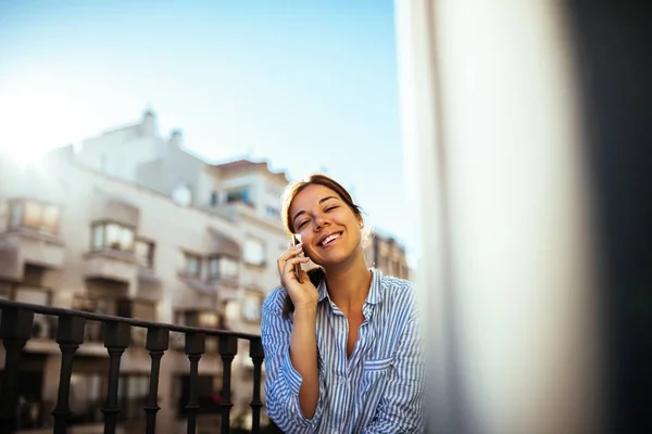 Schöne Frau Telefoniert Während Sie Auf Einem Balkon Sitzt — Stockfoto