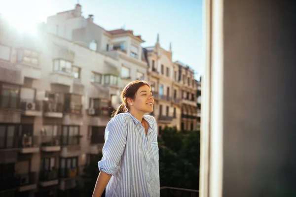 Portrait of a young woman full of life enjoying on the balcony.