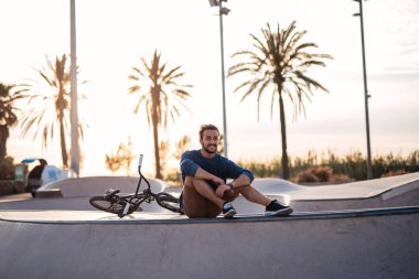 Yakışıklı motorcu bisiklet için hazırlanıyor binmek.